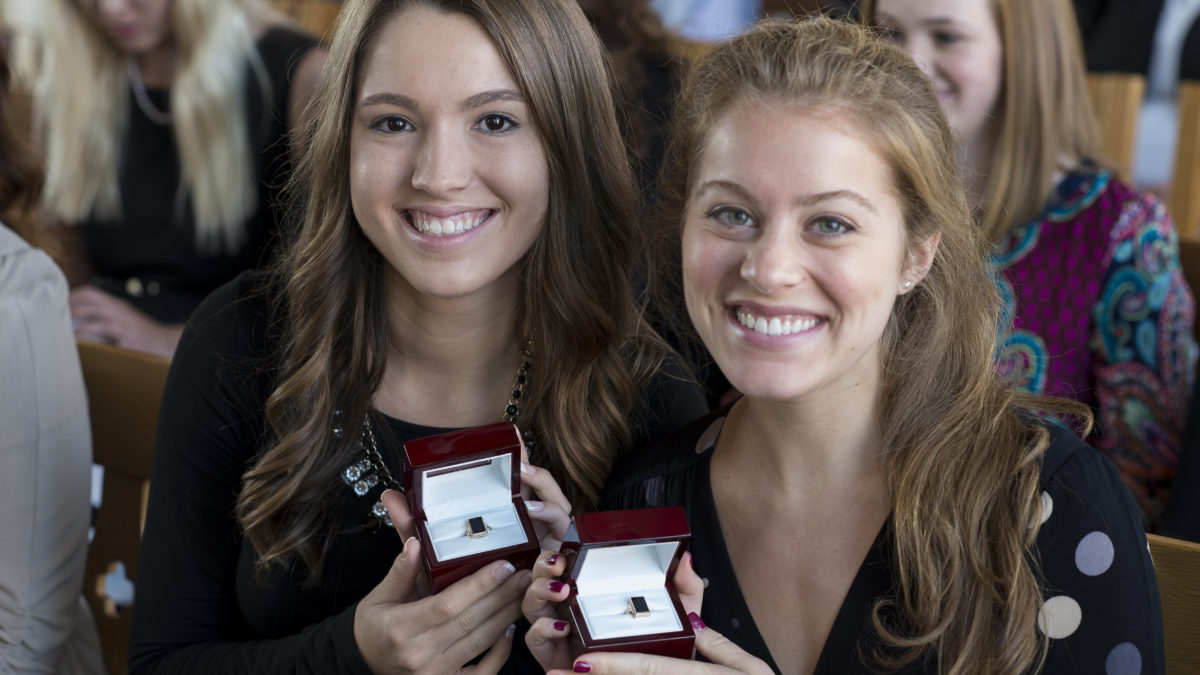 two female students pose with class rings