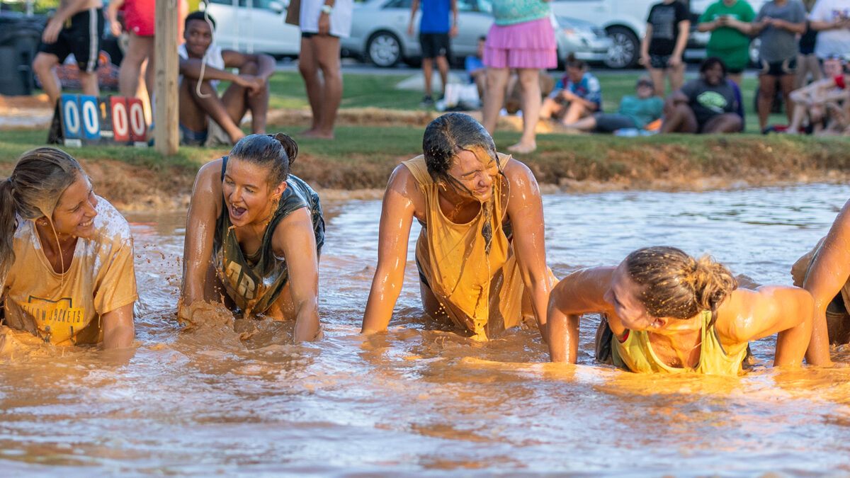 students playing mud volleyball