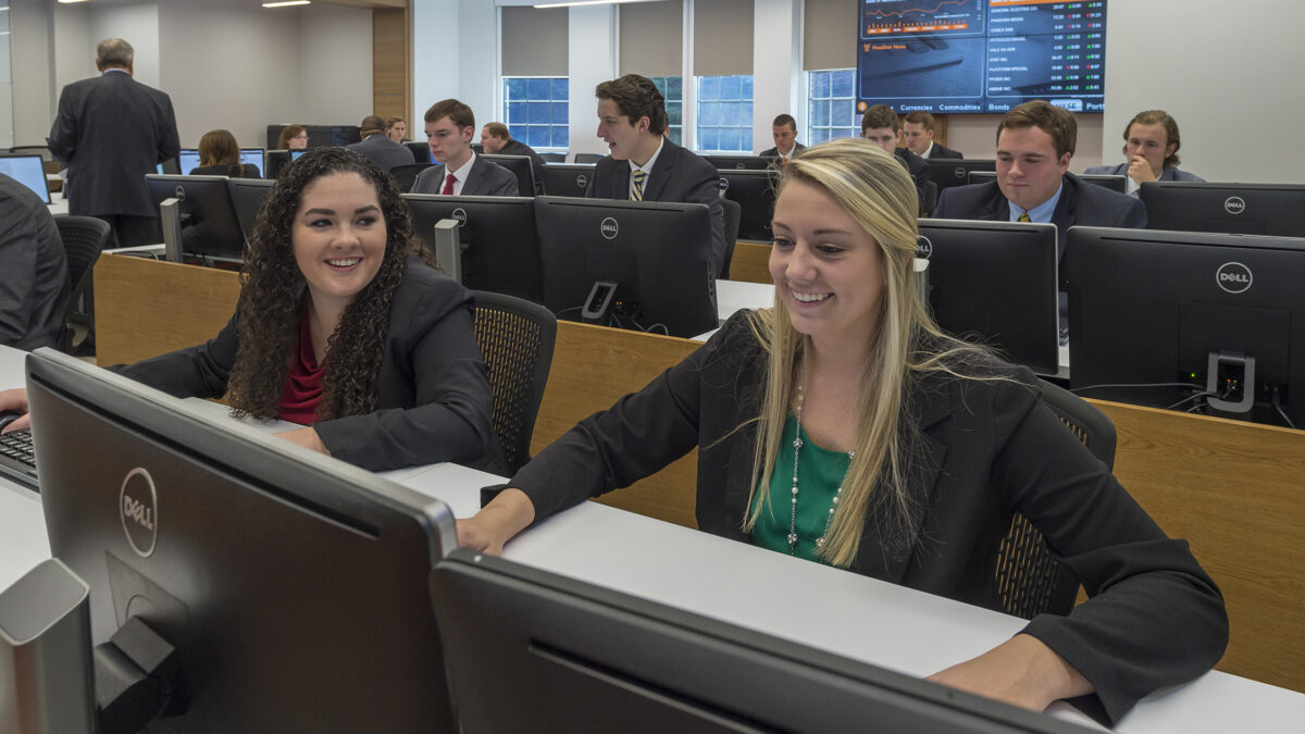 Two female Trust & Wealth Management students chat during class in the Trust & Wealth Management Center.